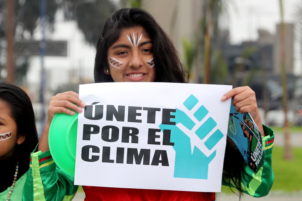 An activist gathers to urge world leaders to take action against climate change in Lima, Peru September 8, 2018. The sigh reads 'Unite for climate'. REUTERS/Guadalupe Pardo - RC1980DE8800