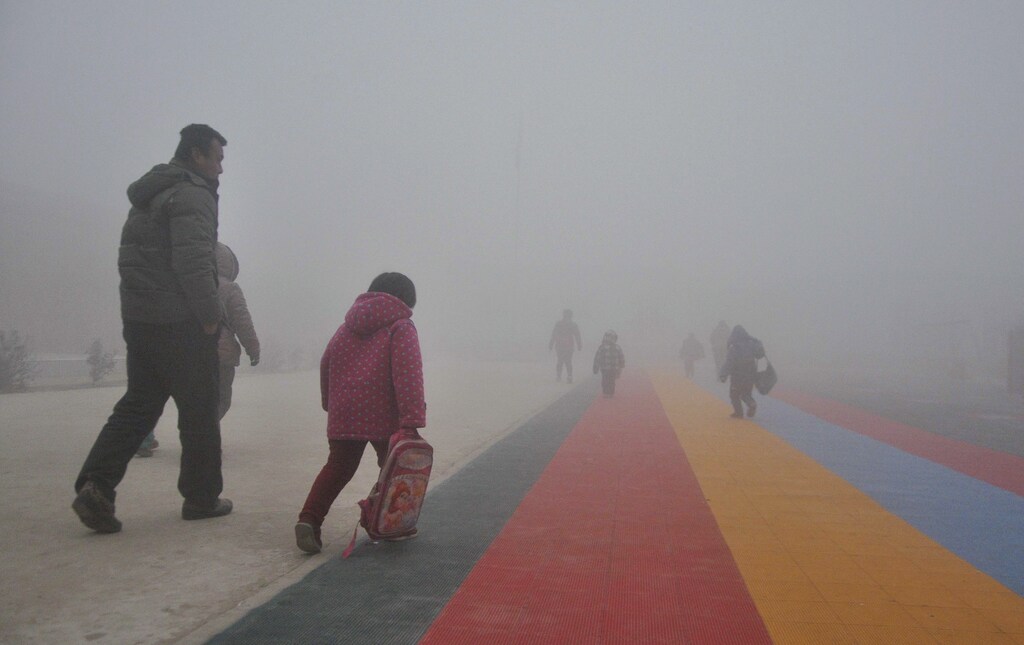 Parents walk primary school students to school amid thick haze in Chiping county, Shandong province January 16, 2015. The National Meteorological Center of China Meteorological Administration (CMA) issued a yellow smog alert early on Wednesday, predicting that smog will persist in most parts of the country for the upcoming days, Xinhua News Agency reported. REUTERS/China Daily (CHINA - Tags: ENVIRONMENT SOCIETY EDUCATION TPX IMAGES OF THE DAY) CHINA OUT. NO COMMERCIAL OR EDITORIAL SALES IN CHINA - GM1EB1G0ZOD01