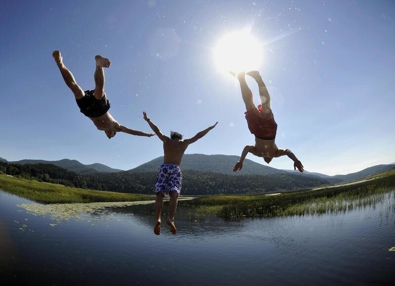 Boys jump into Lake Cerknica July 11, 2010. The lake is the largest intermittent lake in Europe. REUTERS/Srdjan Zivulovic (SLOVENIA - Tags: SOCIETY ENVIRONMENT) - RTR2GB4P