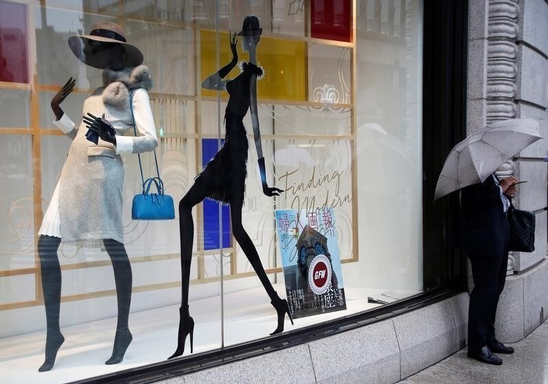 A man stands in front of a shop window at a shopping district in Tokyo, Japan October 28, 2016.