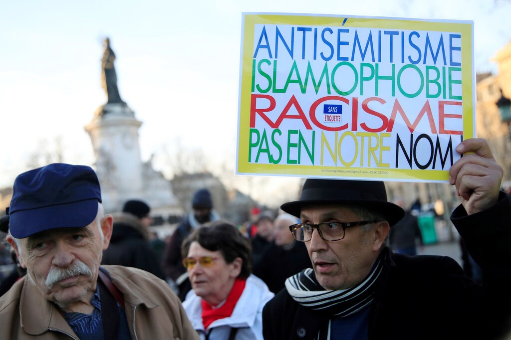People attend a national gathering to protest antisemitism and the rise of anti-Semitic attacks in the Place de la Republique in Paris, France, February 19, 2019. The writing on the sign reads: "Antisemitism, islamophobia, racism - not in our name". REUTERS/Gonzalo Fuentes - RC1C0E9C21B0