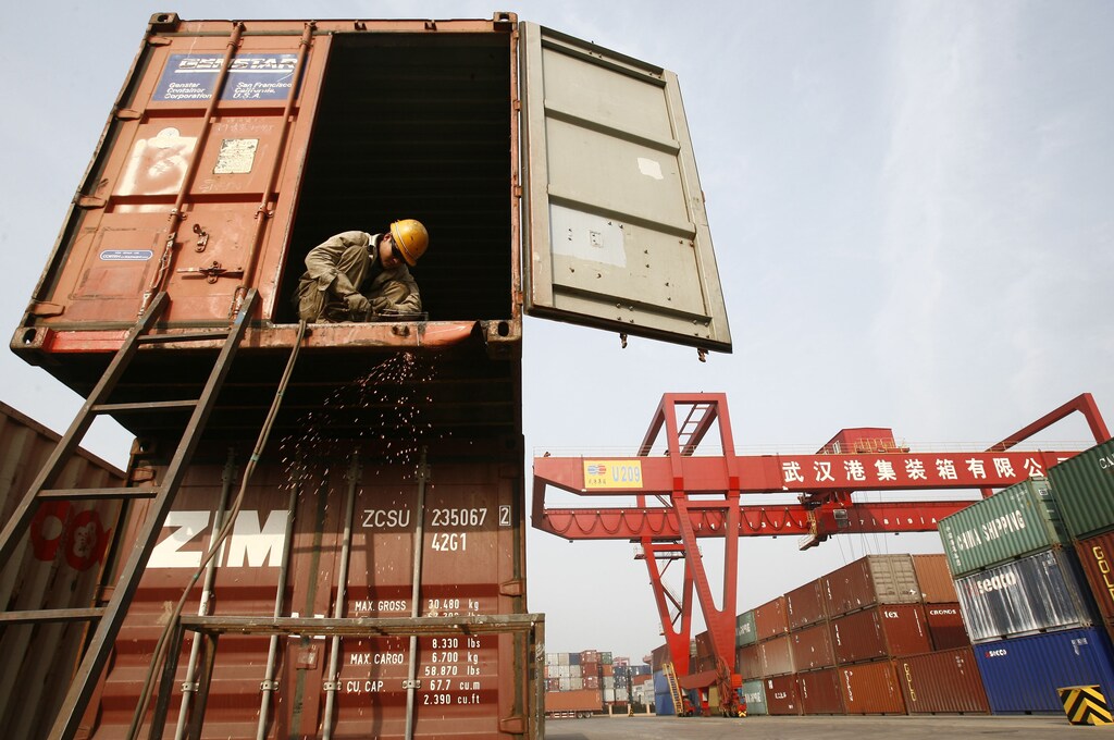 A labourer welds the edge of a container at a port in Wuhan, Hubei province, February 22, 2008.
