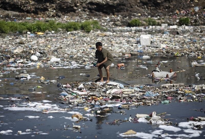 A boy looks for plastic bottles at the polluted Bagmati River in Kathmandu March 22, 2013. This year's theme for World Water Day, which falls on March 22, is "Water Cooperation" and is in line with the celebration of the International Year of Water Cooperation. REUTERS/Navesh Chitrakar (NEPAL - Tags: SOCIETY ENVIRONMENT) - RTR3FBFC