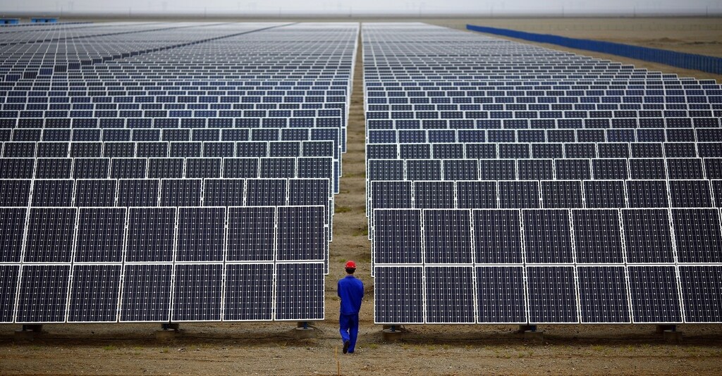 Image: A worker inspects solar panels at a solar Dunhuang.