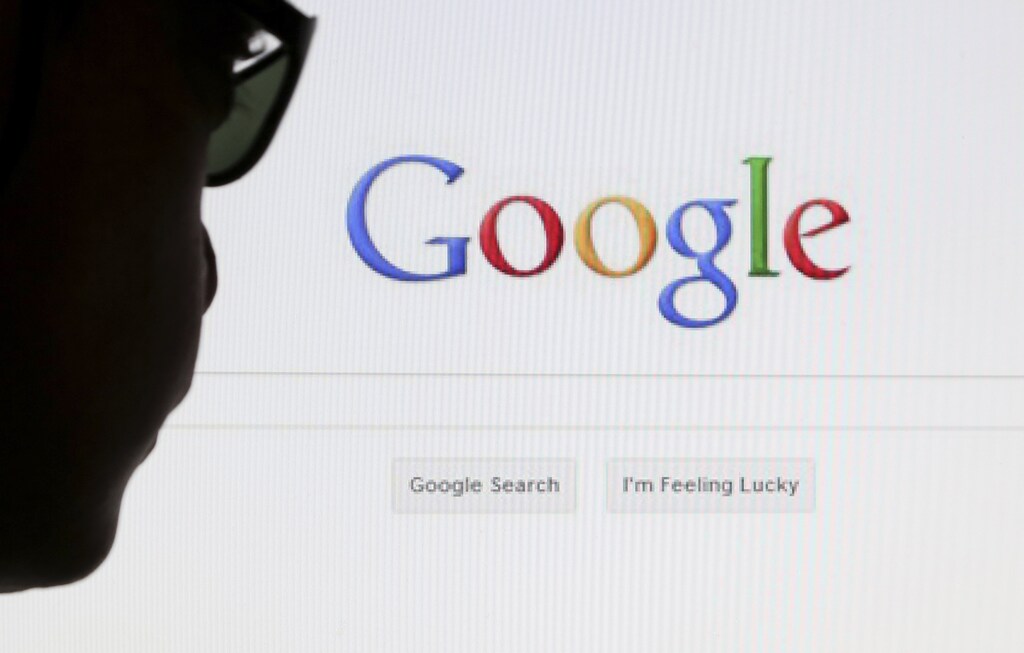 A computer user poses in front of a Google search page in this photo illustration taken in Brussels May 30, 2014. Google has taken the first steps to meet a European ruling that citizens can have objectionable links removed from Internet search results, a ruling that pleased privacy campaigners but raised fears that the right can be abused to hide negative information. REUTERS/Francois Lenoir (BELGIUM - Tags: POLITICS SCIENCE TECHNOLOGY) - GM1EA5V06RA01