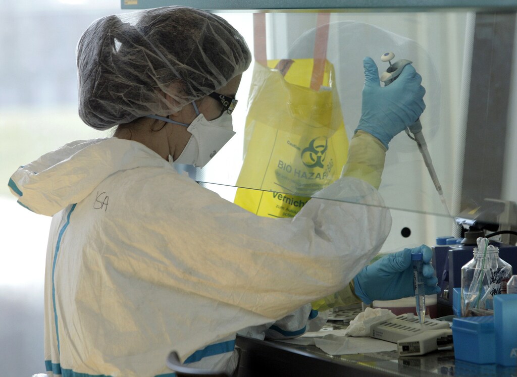 A lab assistant performs an experiment during an inauguration visit of a new P3 level research laboratory against tuberculosis at the School of Life Sciences of the Swiss Federal Institute of Technology (EPFL) in Lausanne in Ecublens near Lausanne March 17, 2010. Financed by the Stavros Niarchos Foundation and the Swiss Government, the lab is open to researchers from EPFL and nearby universities in order to study in vivo strains of Bacillus anthracis, the air-borne pathogen causing tuberculosis. There are around 500 cases of tuberculosis each year in Switzerland alone. REUTERS/Denis Balibouse (SWITZERLAND - Tags: HEALTH SCI TECH) - RTR2BQRF