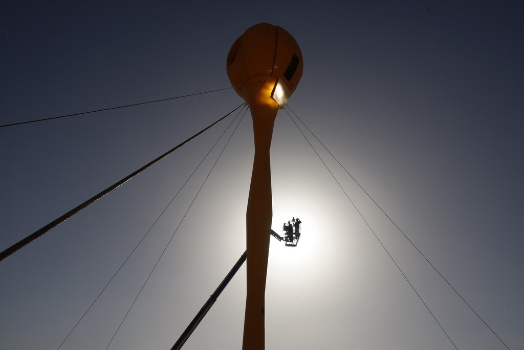 A crane lifts a labourer at a construction site for a hybrid solar power station on Kibbutz Samar February 16, 2009.