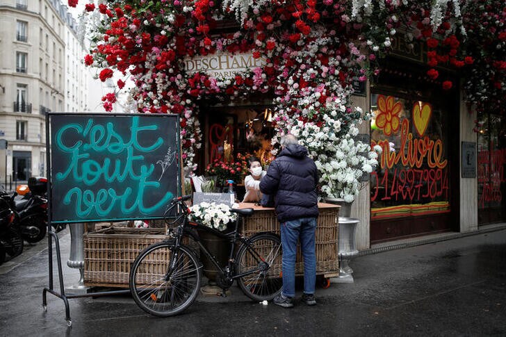 A customer buys some Lily of the Valley flowers, the symbol of Labour Day, from Deschamps flower shop in Paris, following the outbreak of the coronavirus disease (COVID-19), Paris, France, May 1, 2020. REUTERS/Benoit Tessier