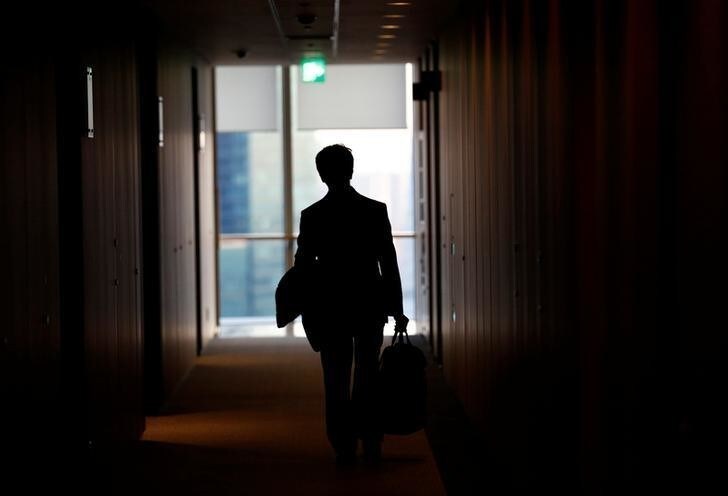 An IT engineer, who does not want to be identified, poses against a window after having an interview with Reuters in Tokyo, Japan, December 7, 2016. Picture taken on December 7, 2016. REUTERS/Kim Kyung-Hoon