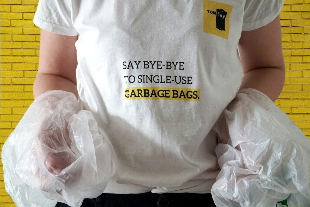 Primer plano de la camiseta de una persona en la que se lee "adiós a las bolsas de basura de un solo uso".