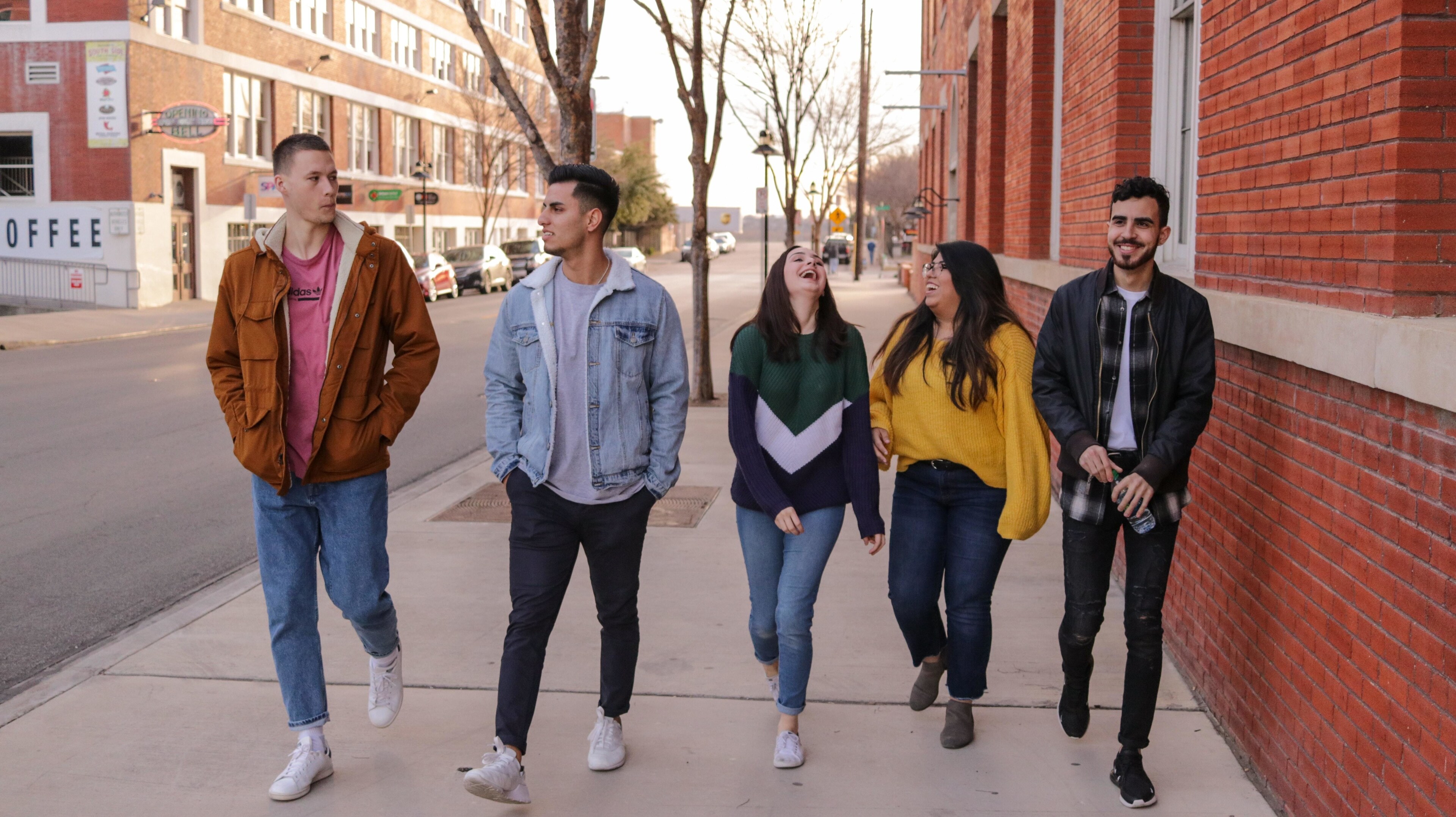 Three men and two women walking side by side