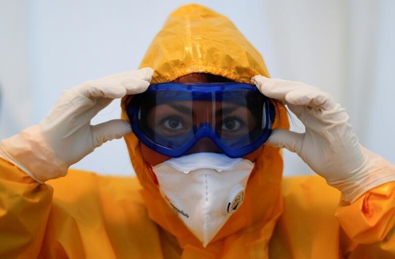 Personal sanitario ajusta sus gafas de protección antes de entrar en un centro de pruebas de la enfermedad COVID19 en el barrio de Reinickendorf, Berlín. 23 marzo de 2020.