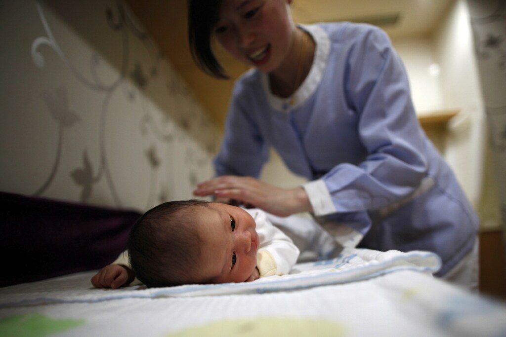 An employee massages a baby at the CareBay maternity care centre in Shanghai December 16, 2011. CareBay is a high-end maternity care centre in providing private services for "Zuo Yue Zi," or confinement period in Mandarin, a Chinese practice for mothers who have just given birth to stay indoors, undergo a restrictive diet and set of activities for a month. Traditionally, mother-in-laws are the ones overseeing the confinement period, but today, the task is left to a nurse or the mother herself. The centre has about 120 employees including maternity care experts, health consultants, beauticians and nutritionists who would look after the new mothers as well as their babies. The cost for a one-month service is between 79,800 yuan ($12,600) and 380,000 yuan ($60,000), covering food, accommodation, slimming exercises and yoga lessons for the mother and nursing services for the child. Picture taken December 16, 2011. REUTERS/Aly Song (CHINA - Tags: SOCIETY HEALTH BUSINESS) - RTR2VL5A