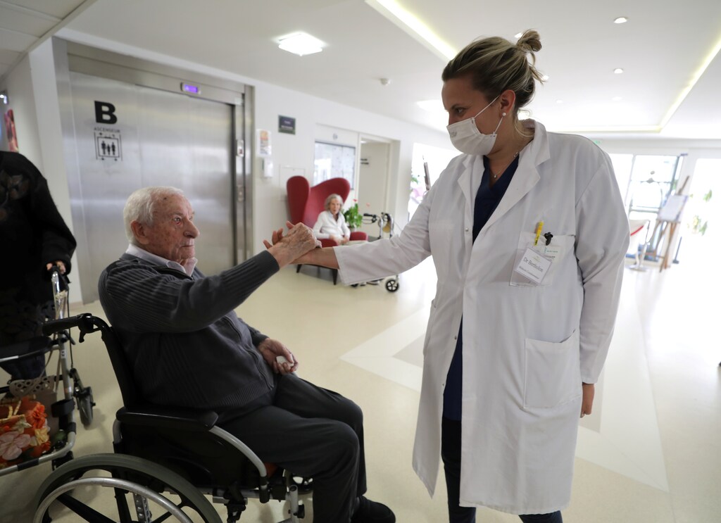 Doctor Bertholon shakes hand with a resident at "Les Figuiers" retirement home (Ehpad - Housing Establishment for Dependant Elderly People) amid the coronavirus disease (COVID-19) outbreak in Villeneuve-Loubet, France, April 23, 2020. REUTERS/Eric Gaillard - RC2GAG936USH