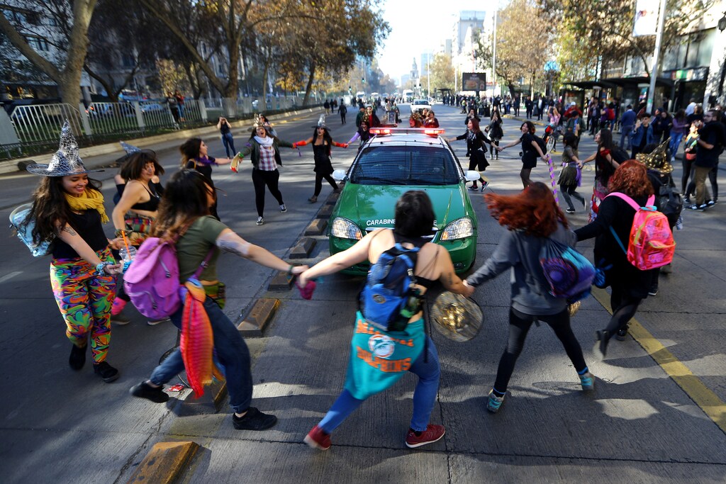 Demonstrators surround a police vehicle during a march against sexism and gender violence in Santiago, Chile.