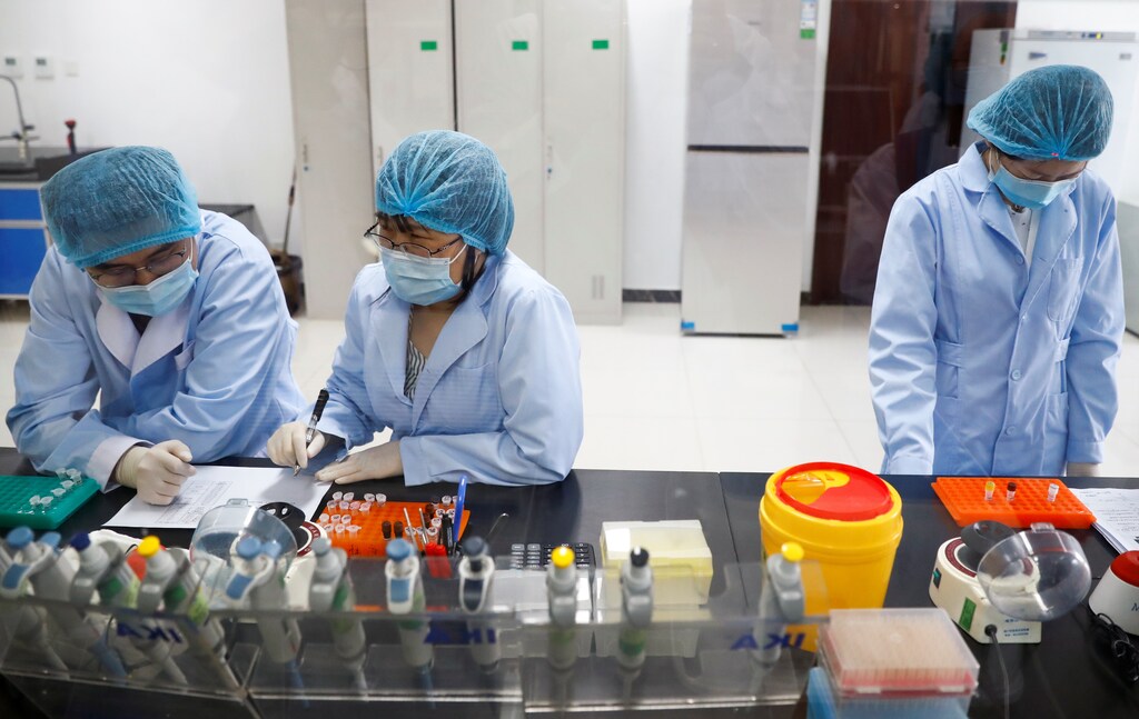 Employees work at the R&D laboratory of the Beijing Applied Biological Technologies Co. during a government organised tour of the facility following the outbreak of the new coronavirus disease (COVID-19), in Beijing, China, May 14, 2020. REUTERS/Thomas Peter - RC27OG9QXS82
