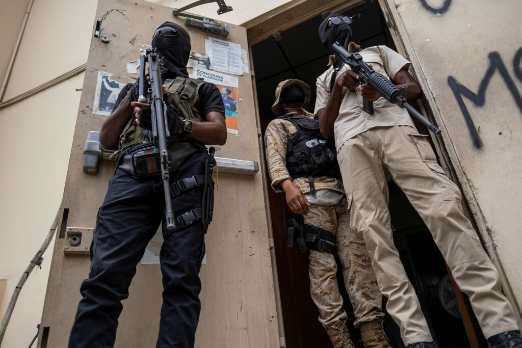 Bodyguards of former senators Steven Benoit and Youri Latortue guard the doorway outside the court house during a hearing following the assassination of President Jovenel Moise, in Port-au-Prince, Haiti July 12, 2021. REUTERS/Ricardo Arduengo - RC20JO92JWF3