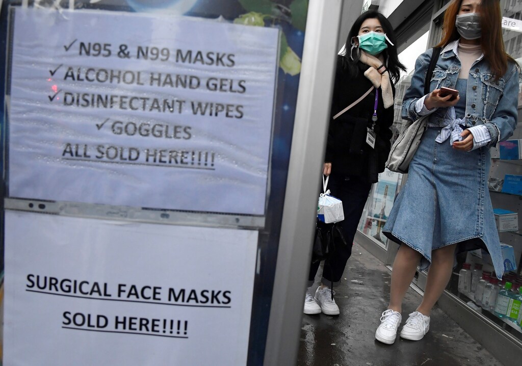 Customers wearing protective face masks are seen leaving a pharmacy in London, Britain, March 4, 2020.