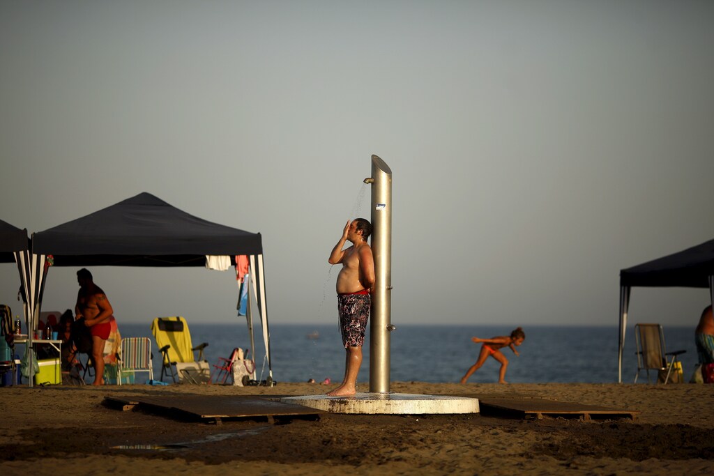 A man takes a shower during the second heat wave of the summer on Sacaba beach in Malaga, southern Spain, July 5, 2015. As Germany and Spain sweated and London sweltered through its hottest July day on record this week, scientists said it is "virtually certain" that climate change is increasing the likelihood of such heat waves in Europe. Temperatures will rise up to 44 degrees Celsius (111.2 fahrenheit) in some parts of Spain and will continue during a week, the Spanish Agency of Meteorology (AEMET) said on Thursday. REUTERS/Jon Nazca - GF10000149506