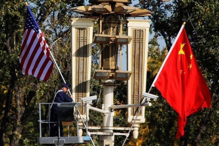 A worker places U.S. and China flags near the Forbidden City ahead of a visit by U.S. President Donald Trump to Beijing, in Beijing, China November 8, 2017. REUTERS/Damir Sagolj