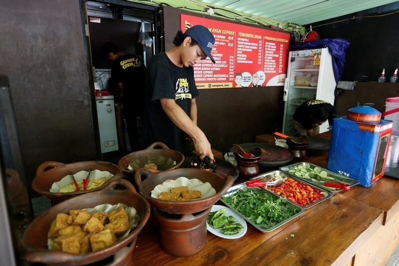 A cook prepares food at a restaurant which offers free meals for people who can show they have recently changed U.S. dollars for Indonesian rupiah at their outlet in Jakarta, Indonesia, September 7, 2018. REUTERS/Willy Kurniawan - RC1883E0F240