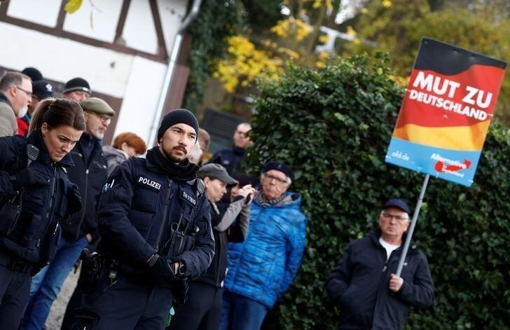 Police stands in front of supporters of the anti-immigrant Alternative for Germany (AFD), blocking the entrance to a property which was used by a German political art group to built a pared-down version of Berlin's Holocaust memorial next to the home of AFD senior member Bjoern Hoecke in the village of Bornhagen, Germany, November 22, 2017. Hoecke in January criticised the memorial in the centre of Berlin and said history should focus on German victims.REUTERS/Kai Pfaffenbach