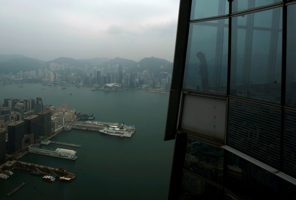 A worker at "sky100", the 100th floor of the International Commerce Centre (ICC), looks at Hong Kong's Victoria Harbour March 23, 2011. REUTERS/Bobby Yip/File Photo GLOBAL BUSINESS WEEK AHEAD PACKAGE - SEARCH 'BUSINESS WEEK AHEAD NOV 7' FOR ALL IMAGES - RTX2S8EQ