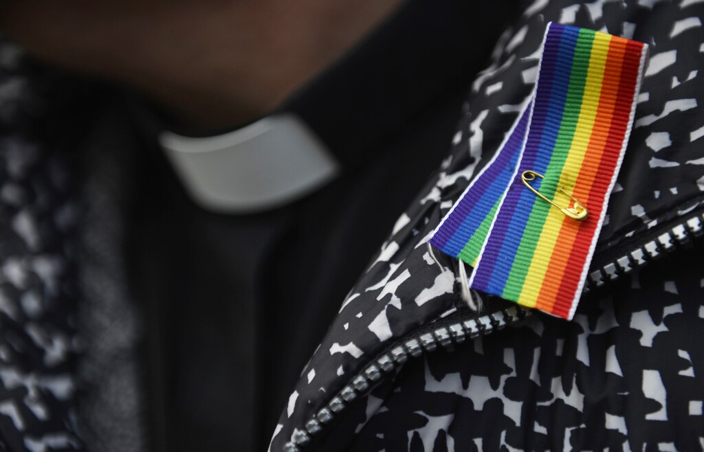 A priest wears a rainbow ribbon during a vigil against Anglican Homophobia, outside the General Synod of the Church of England in London, Britain, February 15, 2017. REUTERS/Hannah McKay - LR1ED2F0T6R0C