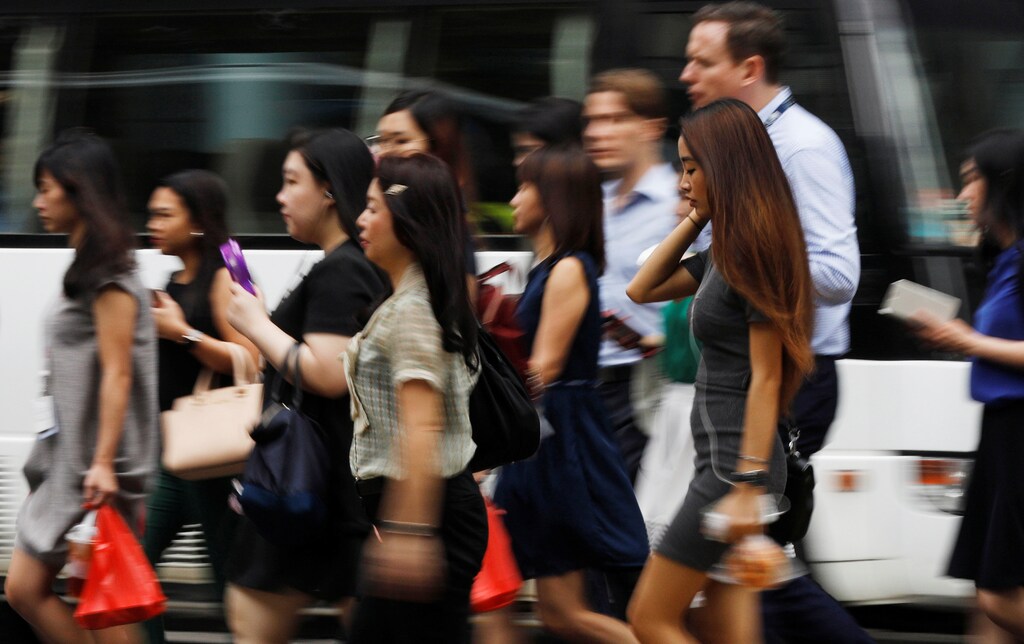 Office workers cross a street in Singapore's central business district April 27, 2017. REUTERS/Edgar Su - RTS143S7