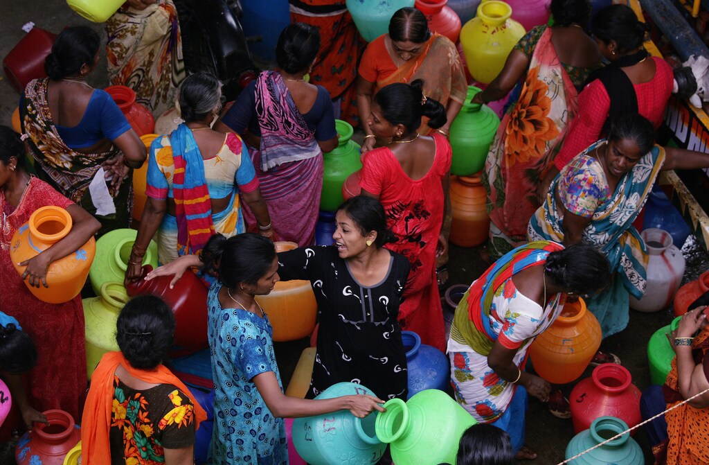 Residents gather to fill empty containers with water from a municipal tanker in Chennai, India, June 25, 2019