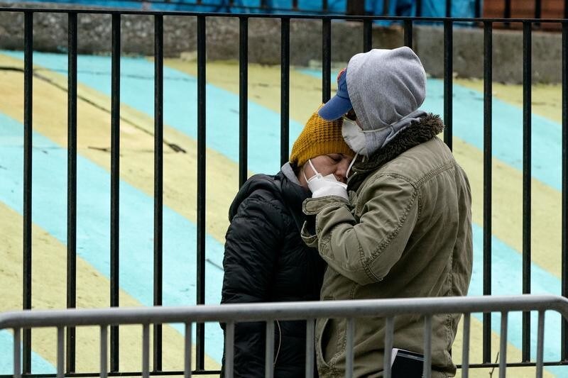 Una pareja espera su turno para que les hagan la prueba de la enfermedad COVID-19, a las puertas del centro hospitalario Elmhurst en el barrio de Queens, ciudad de Nueva York.