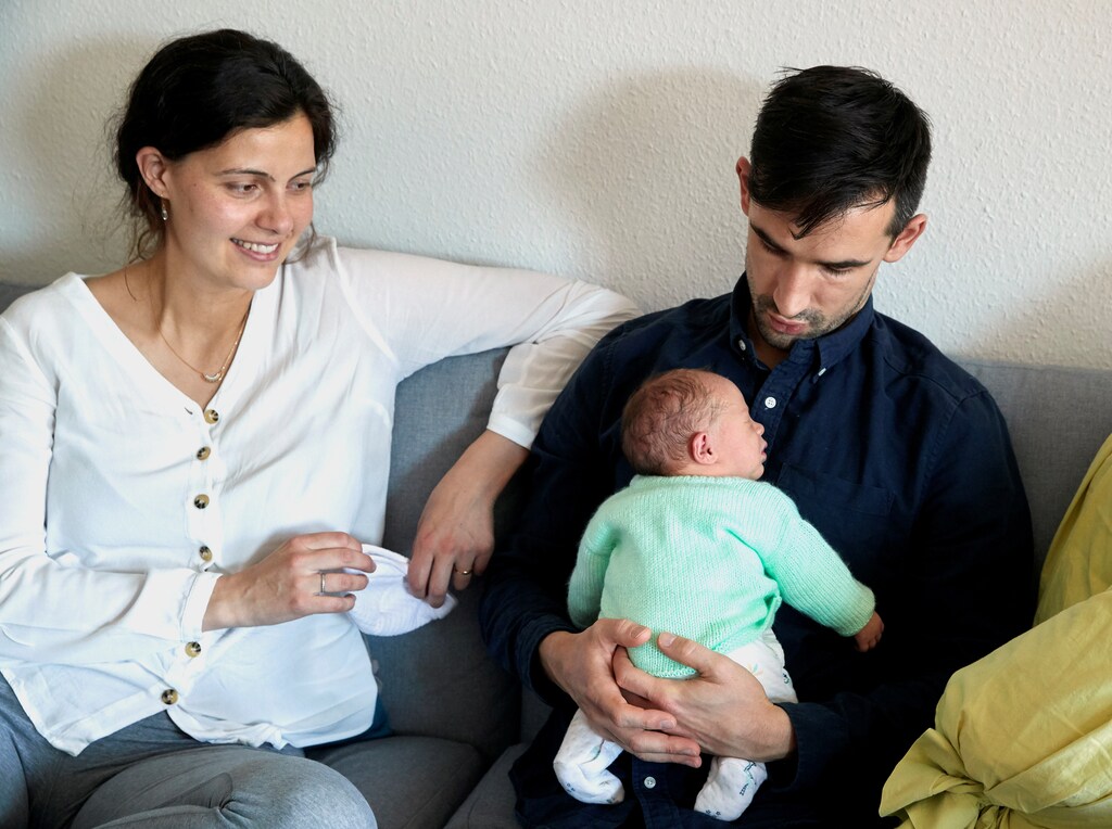 Arnaud Joal holds his new born daughter Bertille next to his wife Noemie Bouchet as relatives are unable to visit due to France's lockdown during the coronavirus disease (COVID-19) outbreak, in Geneva, Switzerland, April 14, 2020. REUTERS/Denis Balibouse - RC2E4G9O17UA