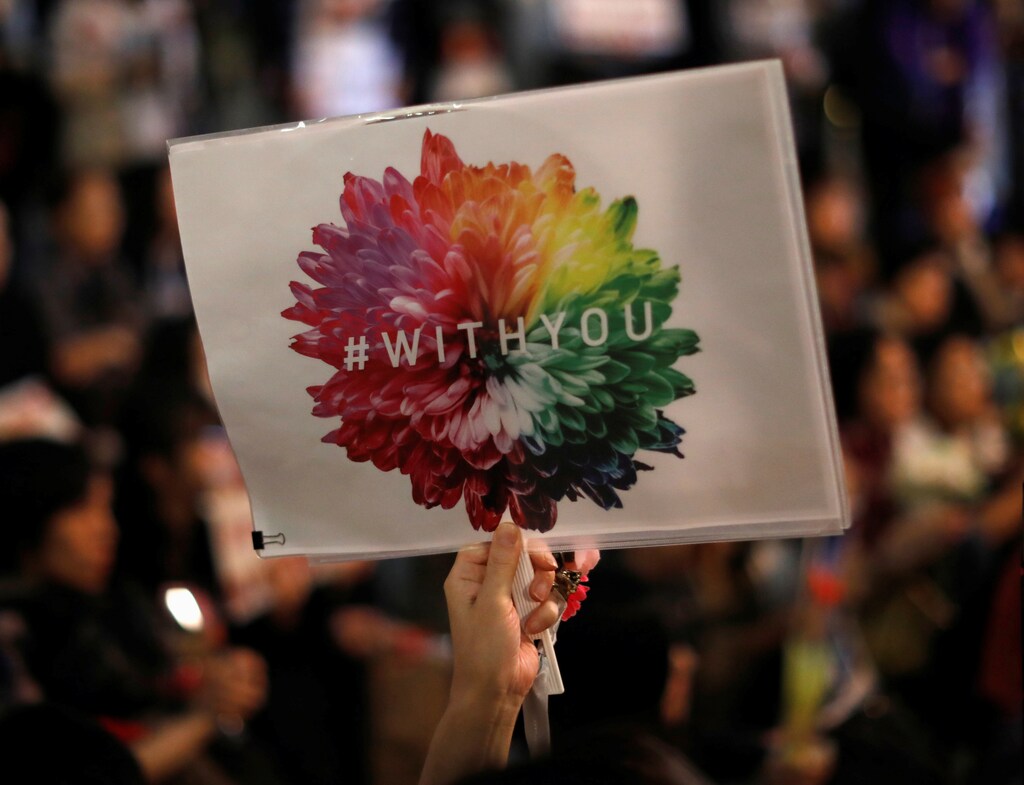 A protester holds a placard at the rally called 'Flower Demo' to criticize recent acquittals in court cases of alleged rape in Japan and call for revision of the anti-sex crime law, in front of Tokyo Station in Tokyo, Japan June 11, 2019. Picture taken June 11, 2019. REUTERS/Issei Kato - RC1D6E746380