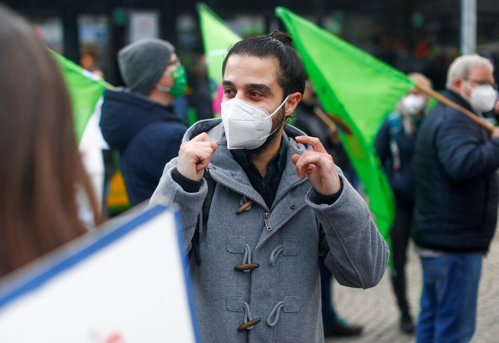 a picture of Syrian migrant Tareq Alaows with a protective face mask on out campaigning