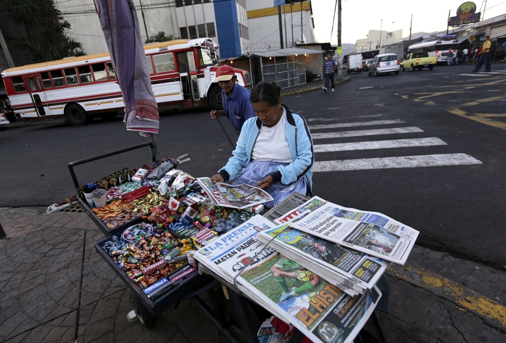 A woman sells newspapers and cigarettes at a cart in downtown San Salvador January 31, 2014.