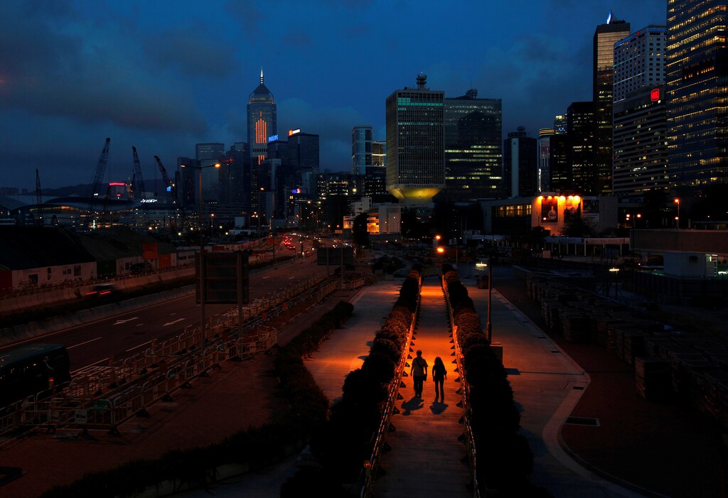 People walk on a pavement at Hong Kong's financial Central district during sunset May 11, 2011.