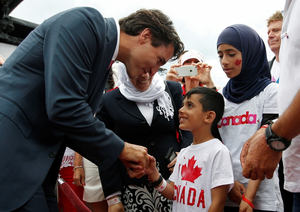 Canada's Prime Minister Justin Trudeau shakes hands with a Syrian refugee during Canada Day celebrations on Parliament Hill in Ottawa, Ontario, Canada, July 1, 2016. REUTERS/Chris Wattie - RTX2JALK