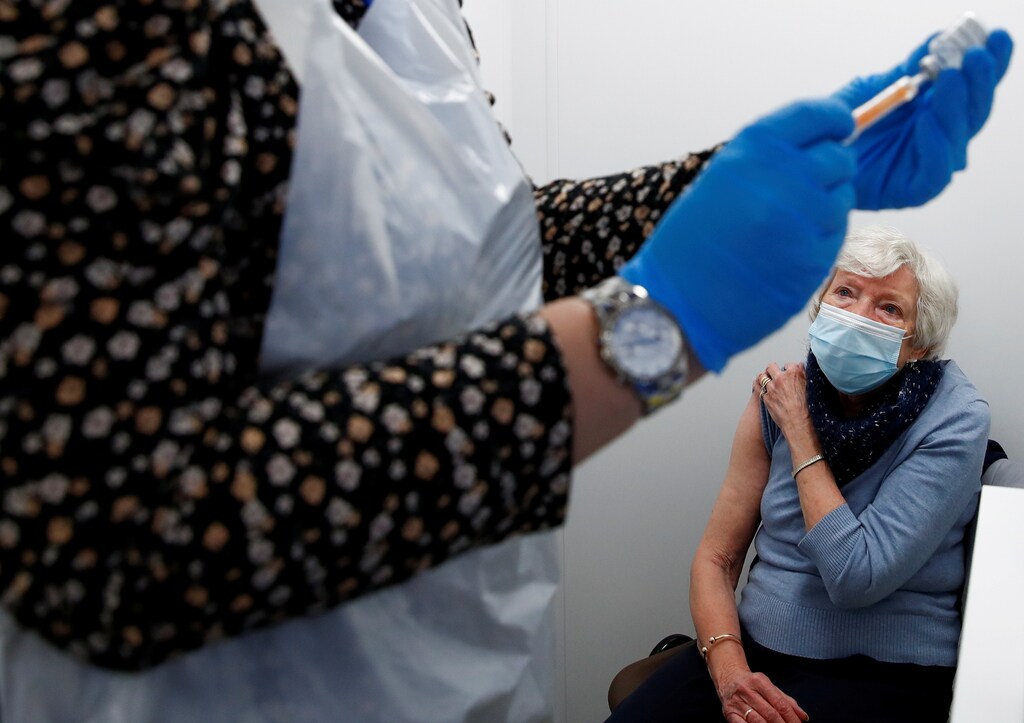 Doreen Vickers, 83, waits as a health worker fills a syringe with a dose of the Oxford/AstraZeneca COVID-19 vaccine at the Appleton Village Pharmacy