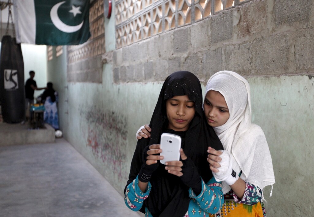 Javeria (L) and Mehek check a selfie after an exercise session at the first women's boxing coaching camp in Karachi, Pakistan February 19, 2016. For the past six months about a dozen girls, aged 8 to 17, have gone to the Pak Shaheen Boxing Club after school to practice their jabs, hooks and upper cuts. Pakistani women have been training as boxers in small numbers and competed in the South Asian Games last year, said Younis Qambrani, the coach who founded the club in 1992 in the Karachi neighbourhood of Lyari, better known for internecine gang warfare than for breaking glass ceilings. REUTERS/Akhtar Soomro SEARCH "THE WIDER IMAGE" FOR ALL STORIES - GF10000324444
