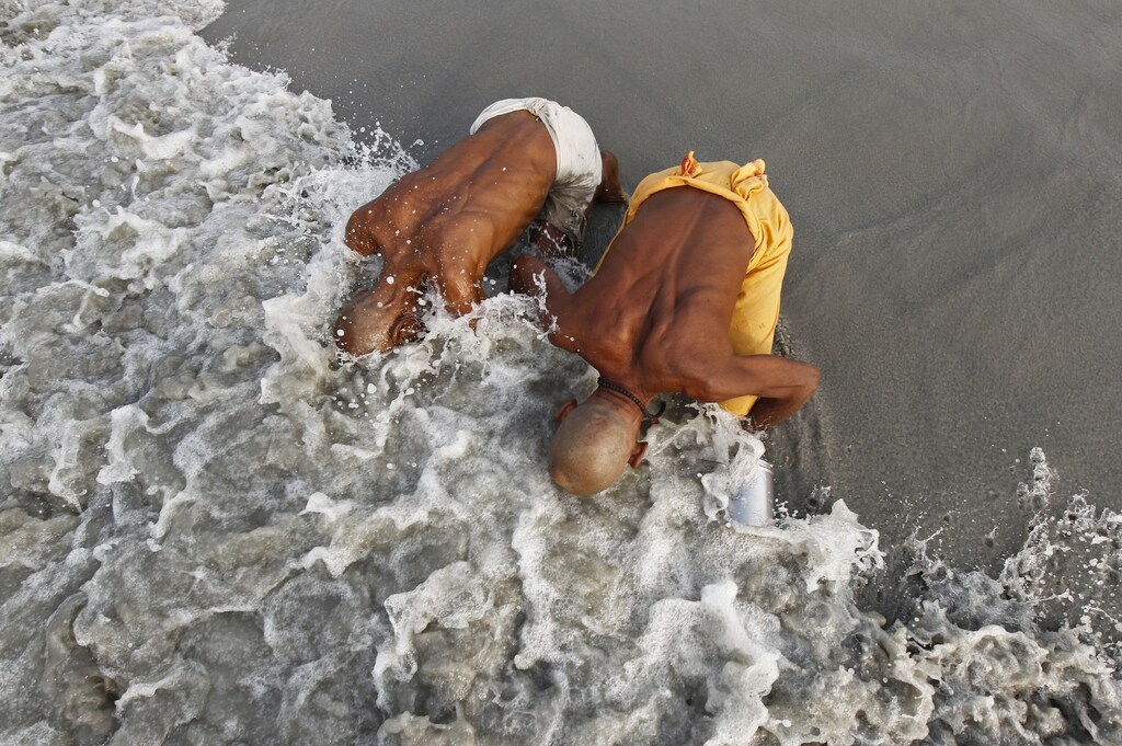 Hindu pilgrims take a dip at the confluence of the Ganges River and the Bay of Bengal, an act which they consider to be holy, at Sagar Island, south of Kolkata January 13, 2014. Hindu monks and pilgrims are making their annual trip to Sagar Island for the one-day festival of "Makar Sankranti" on January 14. REUTERS/Rupak De Chowdhuri (INDIA - Tags: RELIGION SOCIETY TPX IMAGES OF THE DAY) - GM1EA1D19EW01