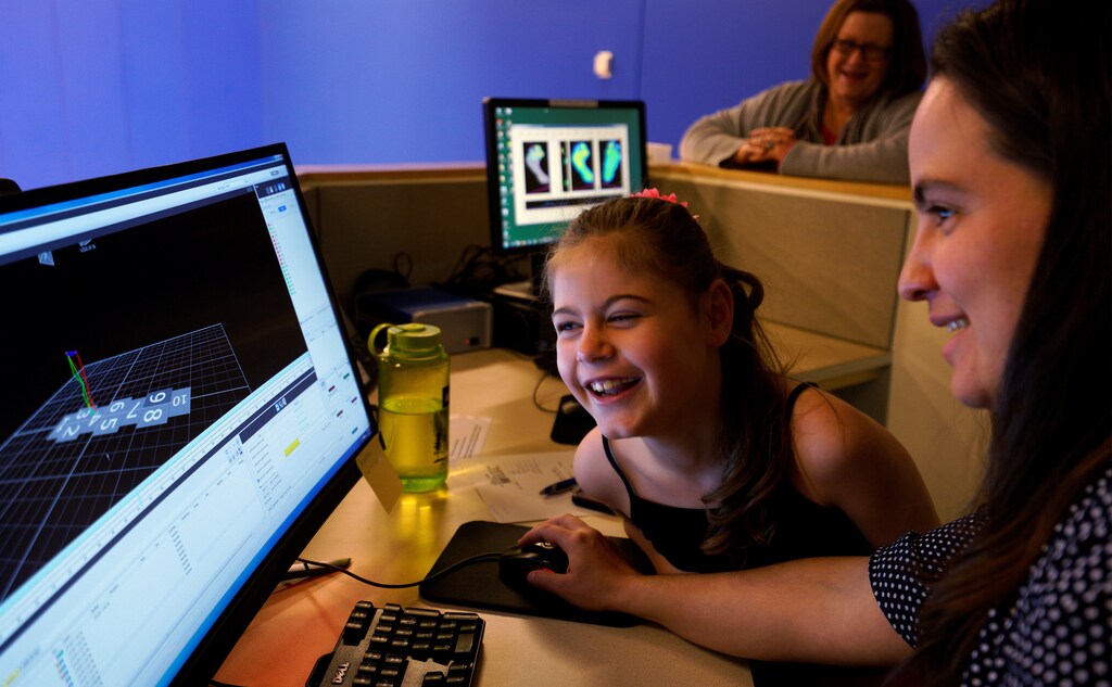 Ryleah Geisner, 8, laughs as she looks at a computer image of herself walking with reflective and surface EMG sensors attached to her body in the Center for Gait and Movement Analysis lab at Children's Hospital Colorado in Aurora, Colorado, U.S., February 9, 2017 with lab engineer Kayla Burnim (R.) Ryleah has cerebral palsy, a congenital disorder of movement, muscle tone, or posture. The lab was using 3-D motion capture technology to analyze Ryleah's body movement and muscle activity while walking and that data will then be used to formulate a treatment plan for her. In the background is Ryleah's grandmother Sandy Geisner. Picture taken on February 9, 2017. REUTERS/Rick Wilking - RC1C3DE6D970