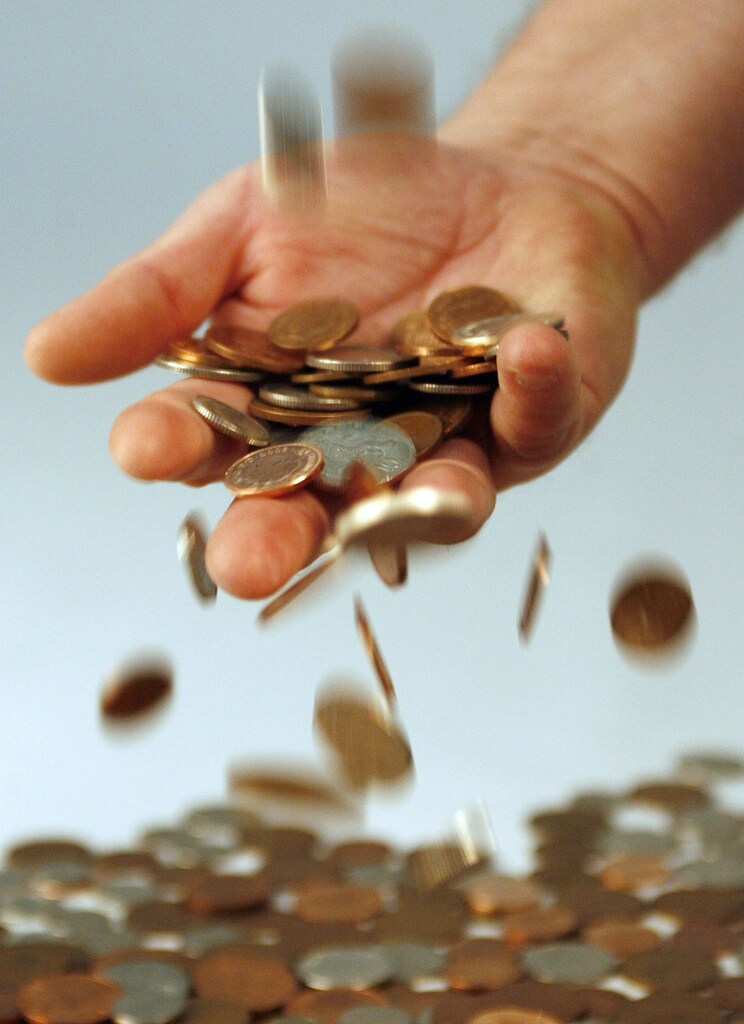 A man poses with coins as he empties a money jar in central England January 16, 2007. The Bank of England narrowly escaped having to explain itself publicly on Tuesday after data showed British inflation hit 3 percent last month, its highest since comparable records began a decade ago. REUTERS/Darren Staples (BRITAIN) - GM1DUKAYZWAA