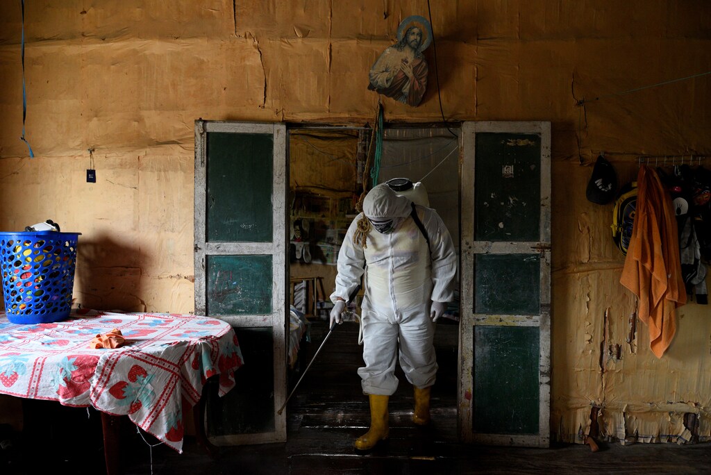 A local volunteer, who is helping to disinfect buildings in his town during the coronavirus disease (COVID-19) outbreak, wears protective clothing as he disinfects a home with a chlorine solution, in Zapotal, Ecuador, May 2, 2020. REUTERS/Santiago Arcos SEARCH "RURAL ECUADOR COVID-19" FOR THIS STORY. SEARCH "WIDER IMAGE" FOR ALL STORIES. - RC2CSG92KHWL
