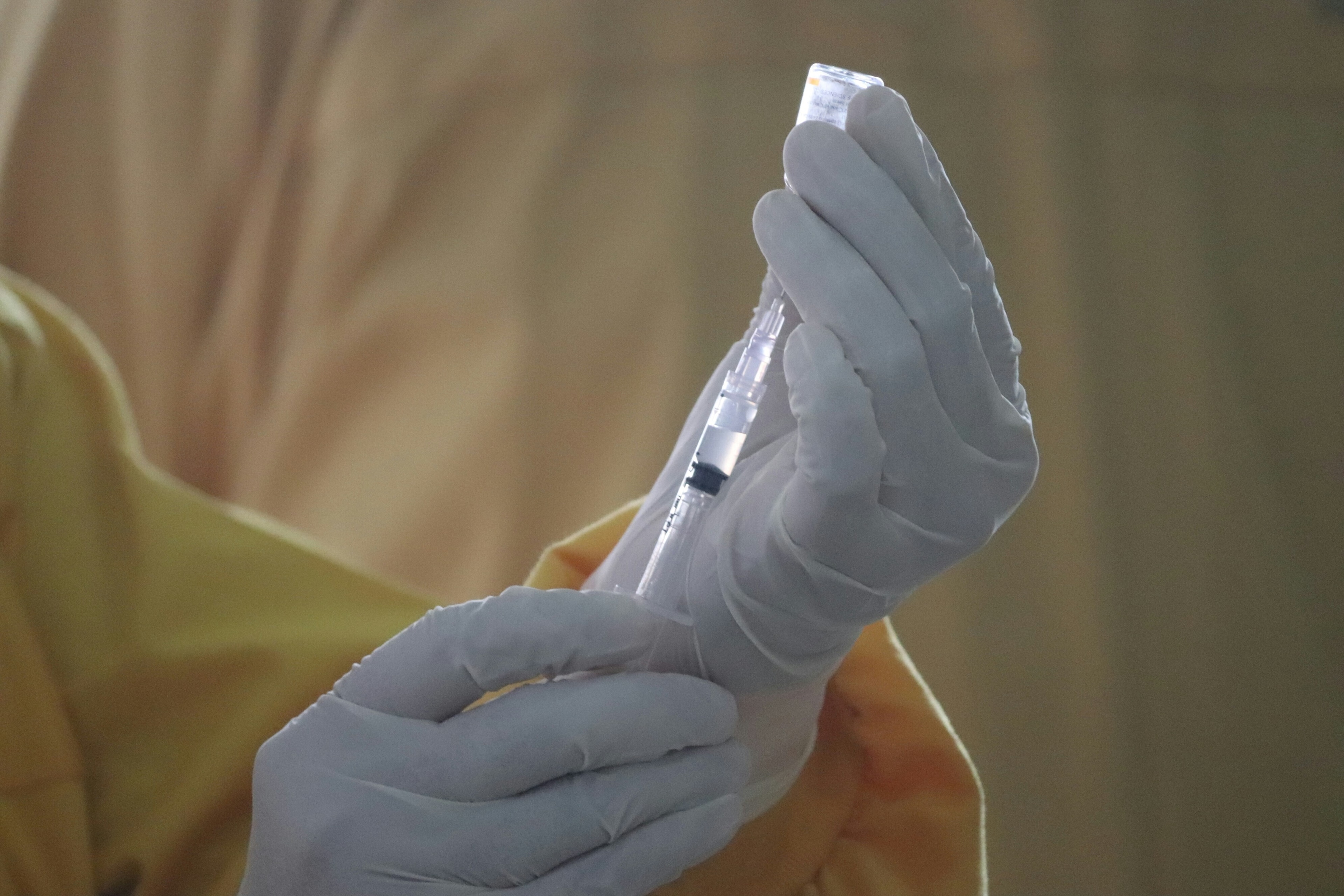 A healthcare operative preparing an injection, illustrating the need for antibiotic resistance