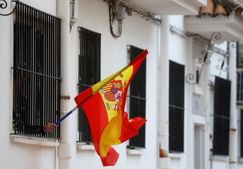 Una mujer agita una bandera española desde la ventana de su casa en apoyo a los trabajadores de la salud, durante el encierro en medio del brote de la enfermedad coronavirus (COVID-19), en Ronda, al sur de España, el 17 de abril de 2020.