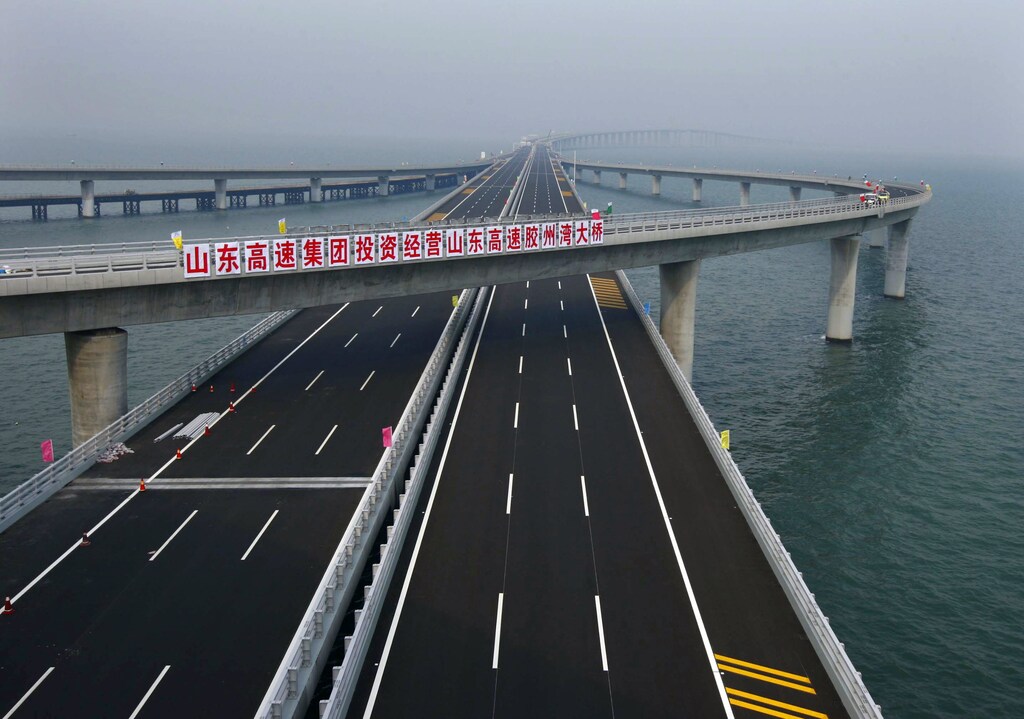 A sign that reads: "Shandong Highway Corp. invests to operate Shandong Highway Jiaozhou Bay Bridge" is seen at Qingdao Jiaozhou Bay Bridge in Qingdao, Shandong province June 27, 2011. The world's longest sea bridge spanning Jiaozhou Bay of Qingdao City, Shandong Province, opened on Thursday, June 30, 2011. The bridge is 36 km (22 miles) long, Xinhua News Agency reported. Picture taken June 27, 2011. REUTERS/China Daily (CHINA - Tags: SOCIETY) CHINA OUT. NO COMMERCIAL OR EDITORIAL SALES IN CHINA - GM1E76U1I1G01