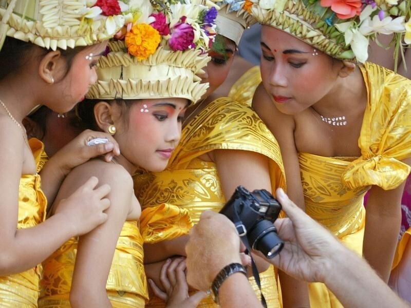 Balinese girls dressed in ceremonial outfits view pictures on atourist's digital camera as they prepare for a special purificationprocession, part of a "Ngenteg Linggih" celebration for the Pura DalemBentuyung temple in Ubud on the Indonesian island of Bali. The numberof tourists visiting Indonesia fell in August, nearly a year after theBali bomb blasts, while arrivals fell almost 20 percent in the firsteight months of 2003, the statistics bureau said on Thursday.