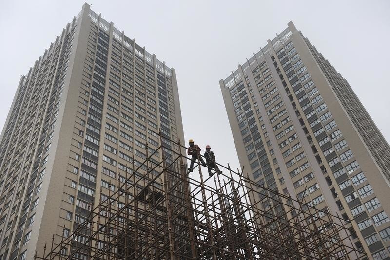 Labourers install scaffolding near recently finished buildings at a residential construction site in Hefei, Anhui province March 1, 2011. China has ordered local authorities to implement existing property tightening measures or face punishment, the official Xinhua news agency said on Sunday, reflecting Beijing's resolve to tame sky-high property prices. REUTERS/Stringer (CHINA - Tags: BUSINESS CONSTRUCTION) - RTR2J9Z5
