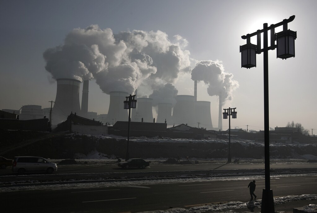 A man walks near a coal-fired power plant on the outskirts of Datong, Shanxi province, November 20, 2009. China will raise power prices for non-residential users by around 5.4 percent from Friday, the first rise since July 2008, to compensate grid firms that lost out because of a government cap on prices. REUTERS/Jason Lee (CHINA ENERGY ENVIRONMENT BUSINESS) - RTXQXVR