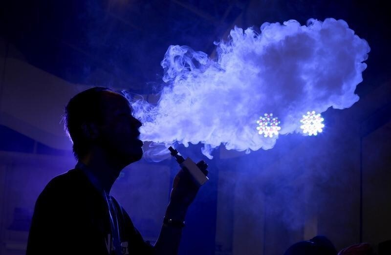 An exhibitor staff member uses an electronic cigarette at Beijing International Vapor Distribution Alliance Expo (VAPE CHINA EXPO) in Beijing, July 24, 2015. According to the organizer, the Expo, which is held in Beijing from July 23 to 25, attracts over 120 companies, including global high-end e-cigarette and e-liquid brands. Chinas capital city unrolled ambitious new curbs on smoking in early June. Under the new rules, anyone in Beijing who violates the ban, which includes smoking in restaurants, hotels, schools and hospitals as well as in certain outdoor public places, must pay a 200 yuan ($32.25) fine.